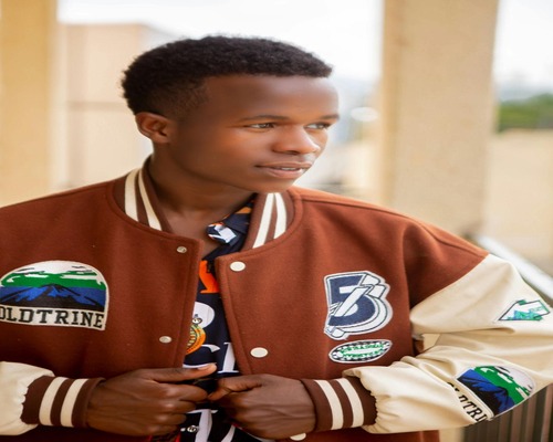 Brown jacket with various patches, including mountains, number 73, and other unique designs.