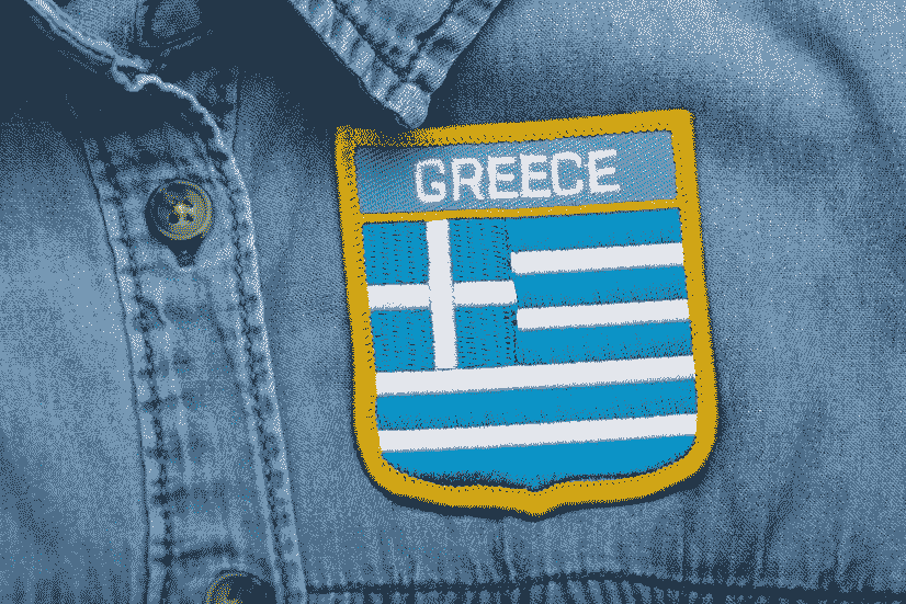 Close-up of a Greece embroidered patch on a denim shirt, featuring blue and white design