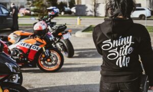 a woman standing in front of a row of motorcycles