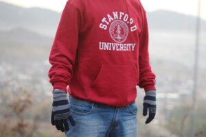 Person in a red Stanford University hoodie and gloves standing outdoors