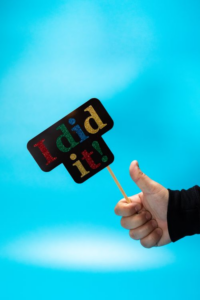 Hand giving a thumbs up next to an 'I did it!' sign to celebrate achievements