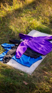 Purple, blue, and black hoodies on a blanket, comparing popular hoodie fabrics.