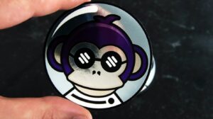 Hand holding a purple monkey patch, showing funny morale patches on social media