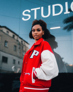 Woman wearing a red varsity jacket with a white letter patch, showcasing popular styles of Greek letter patches.